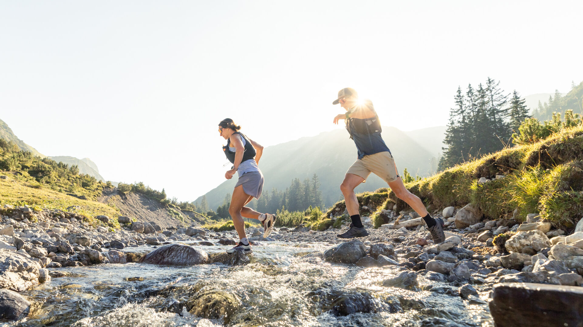 Zwei Trailrunner überqueren dynamisch den Lech