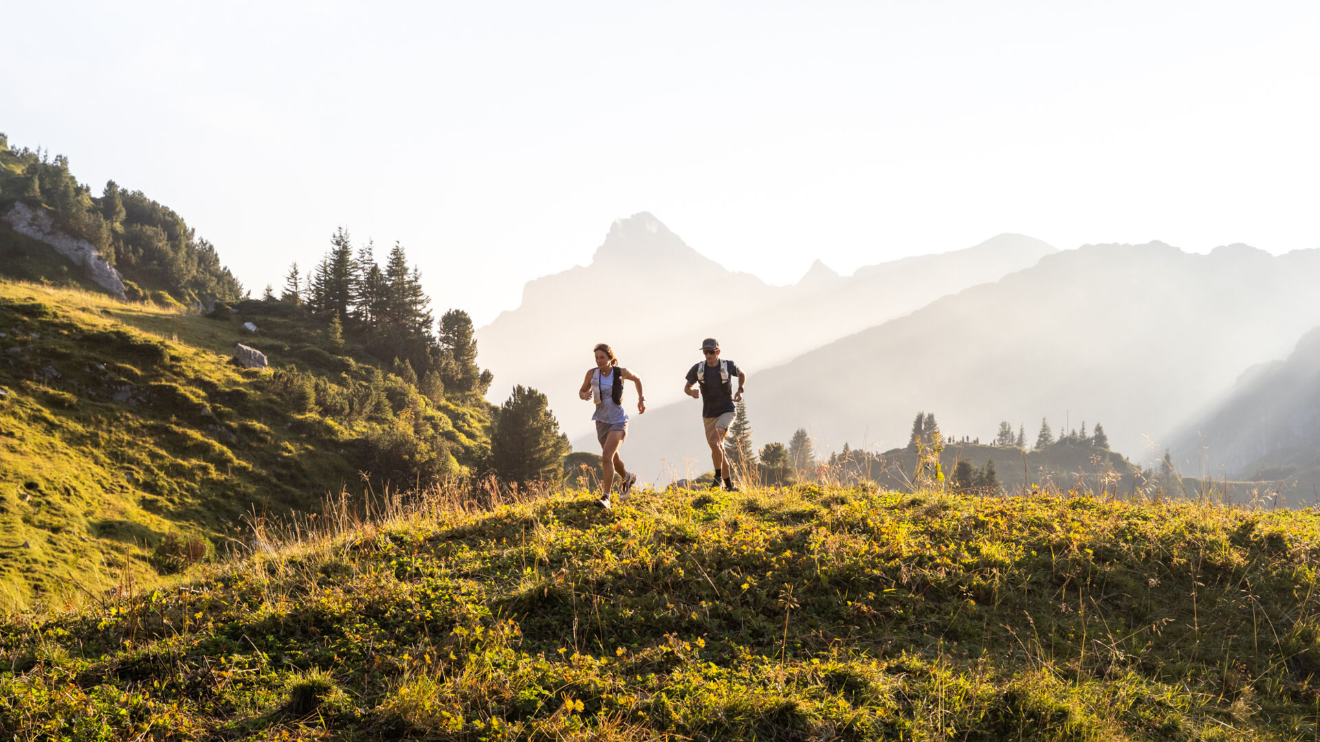 Zwei Trailrunner laufen durch die Berglandschaft von Lech 