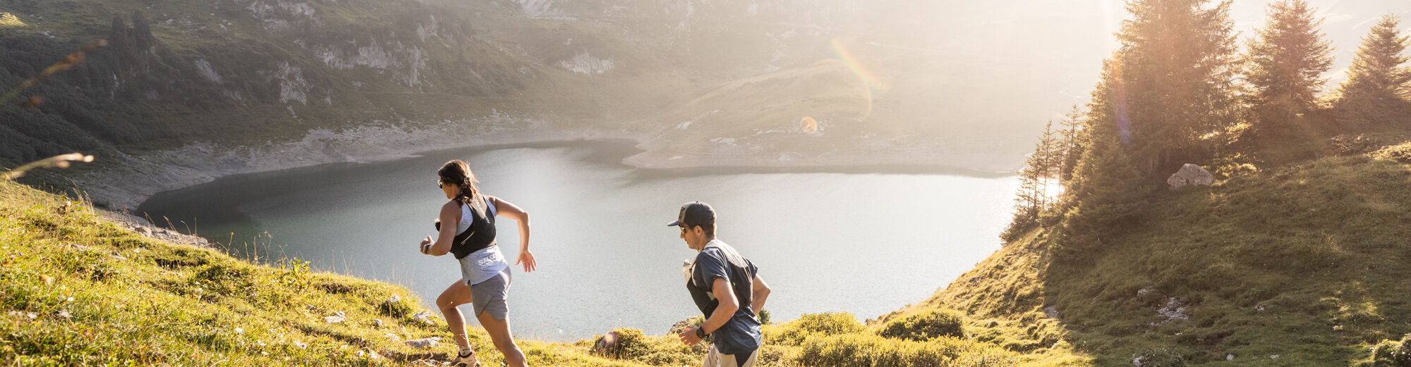 Zwei Trailrunner laufen entlang der Strecke oberhalb des Formarinsee