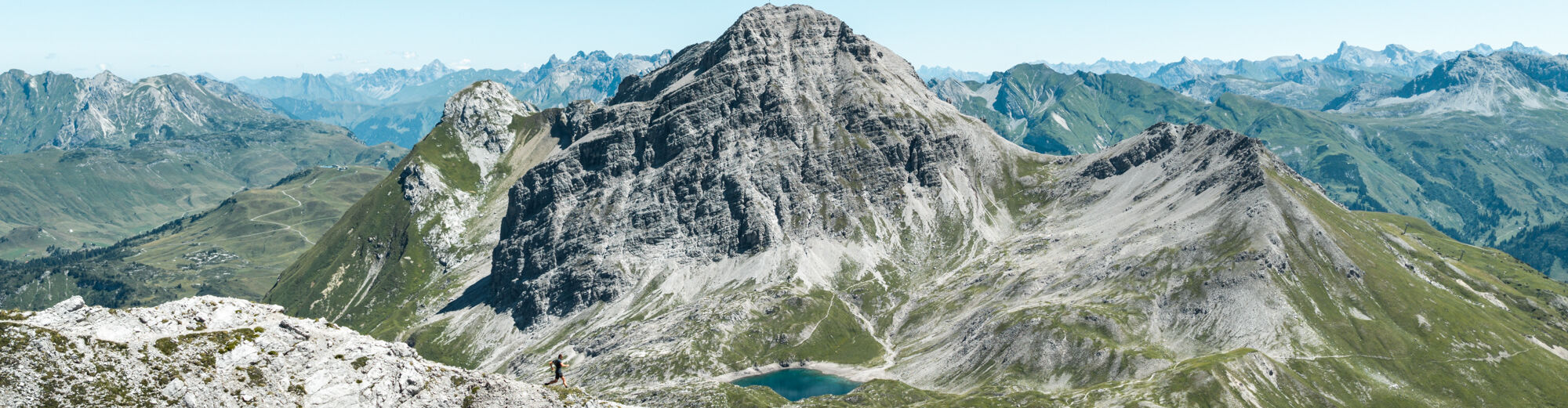 Ein Trailrunner läuft am Felsrücken einen Grat im Gebirge entlang